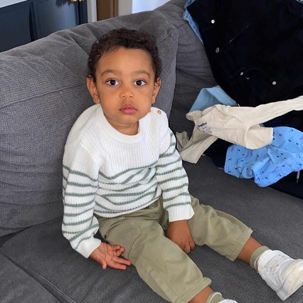 Isaïah a rejoint le concours — aidez-le/la à gagner de superbes lots ! architecture, boy, building, child, clothing, couch, cushion, face, footwear, furniture, head, homedecor, indoors, male, pants, person, photography, portrait, shoe, sitting