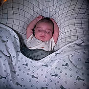 Emilio participe au concours pour gagner de l'argent avec cette photo : baby, sleeping, blanket, pillow, infant, bed, cozy, arms_up, patterned_blanket, soft_lighting, peaceful, indoors, cute, child, resting, head, face, sleepwear, comfort, toddler