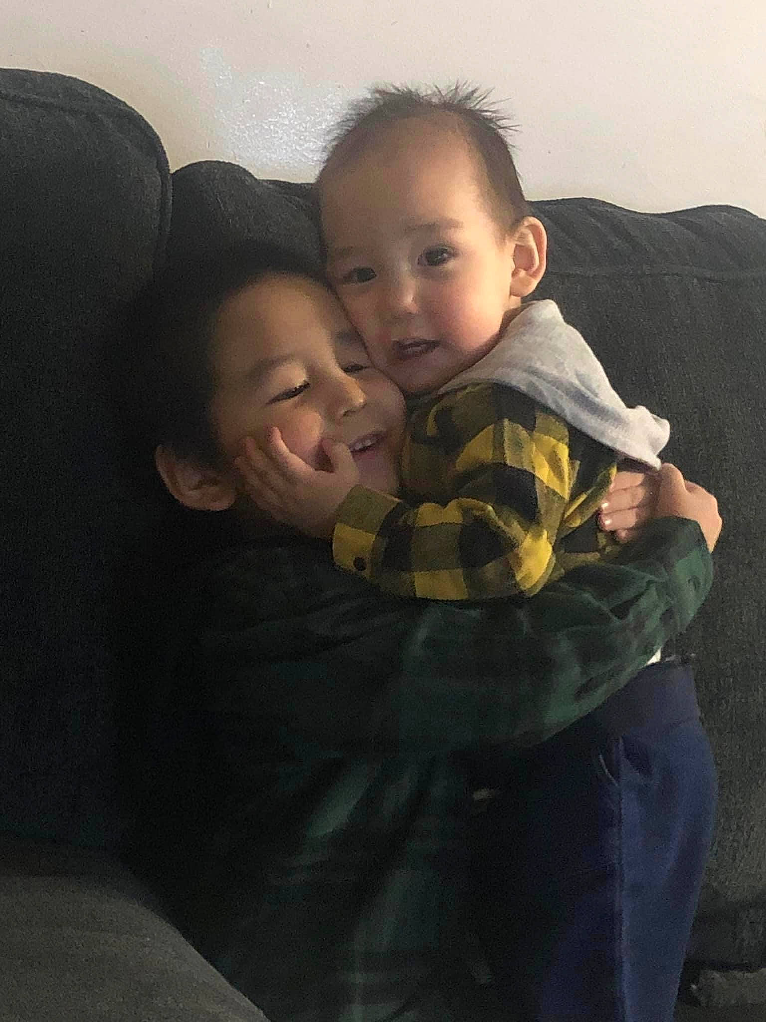 Nathaniel is registered to the contest to win money with this photo: abdomen, baby, child, comfort, couch, darkness, eye, flash_photography, fun, fur, gesture, happy, hug, interaction, iris, joy, lap, person, room, sitting