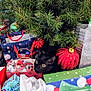 black_cat, christmas_tree, christmas_ornament, gift_bags, holiday, decorations, pine_branches, red_bow, red_ornament, green_box, wrapping_paper, festive, indoor, pet, curious, holiday_season, celebration, animal, christmas, present