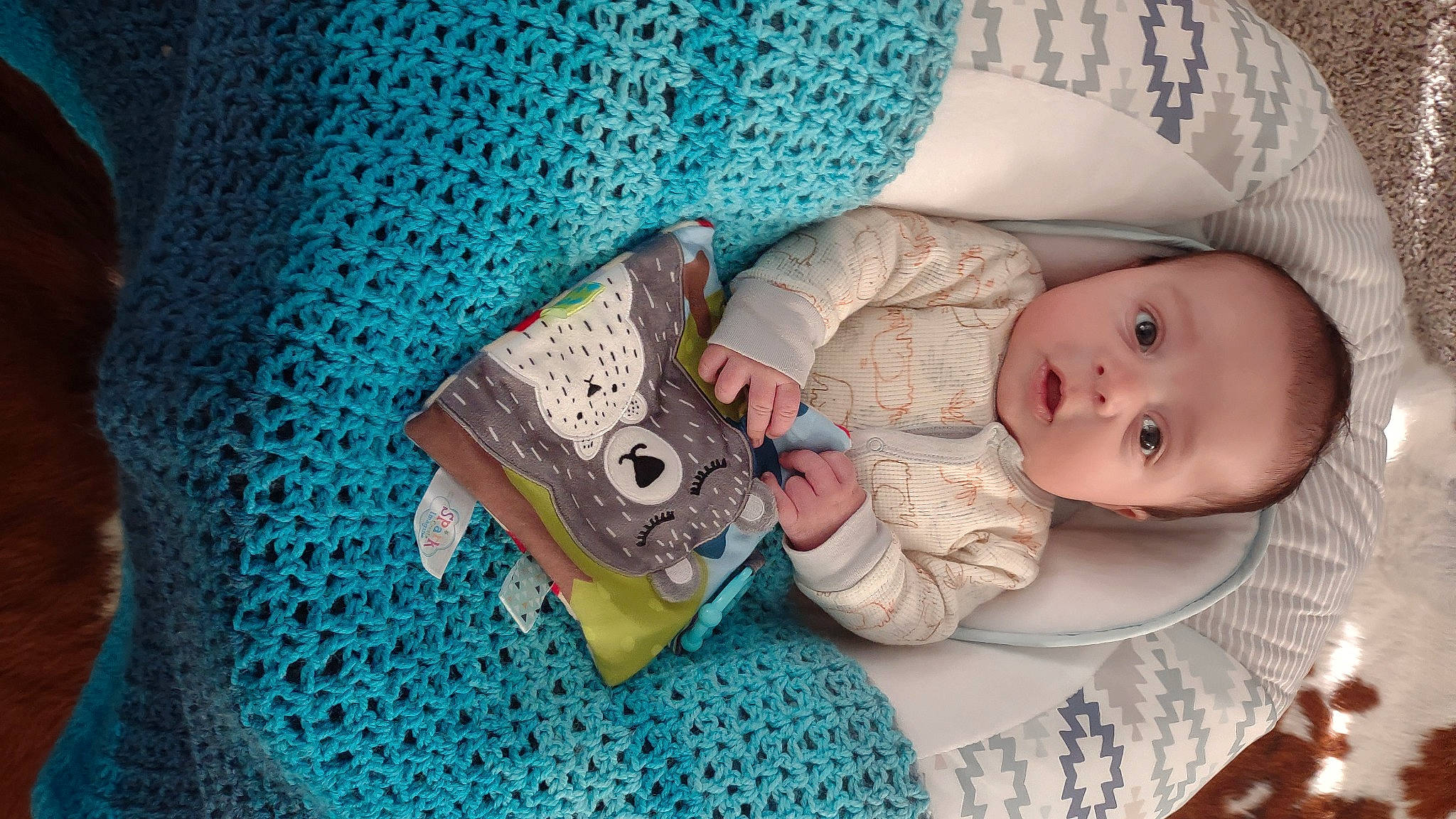 Uriel is registered to the contest to win money with this photo: baby, baby_products, baby_sleeping, baby_toddler_clothing, blue, child, comfort, craft, electric_blue, fashion_accessory, green, hand, headgear, linens, pattern, person, room, sitting, skin, sleeve