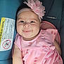 baby, child, smile, pink_dress, headband, flower, car_seat, infant, cute, happy, portrait, watermelon_pattern, clothing, seatbelt, young_child, closeup, indoors, person, baby_girl, sitting