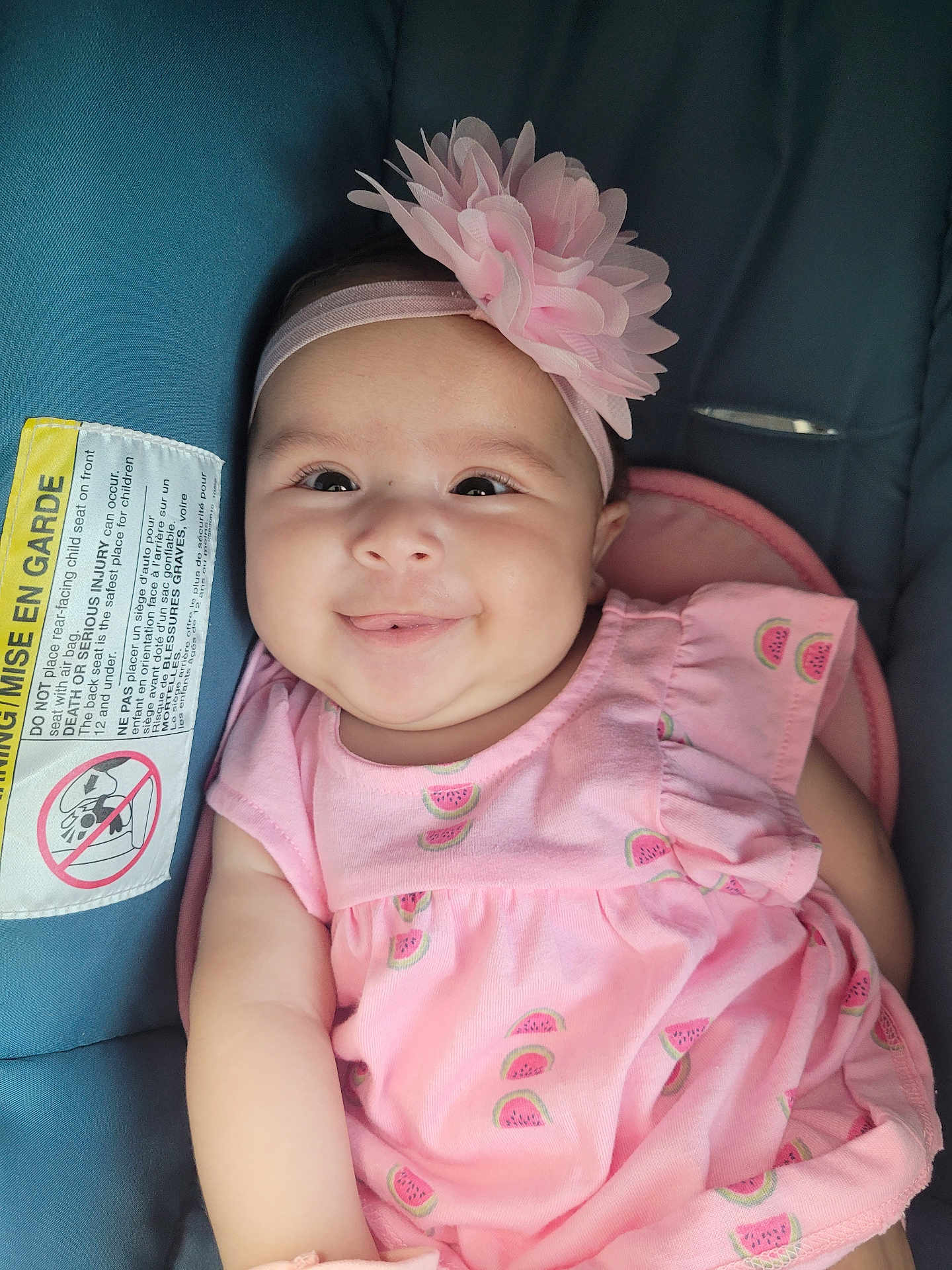 Isabella joined the competition — help win amazing prizes! baby, child, smile, pink_dress, headband, flower, car_seat, infant, cute, happy, portrait, watermelon_pattern, clothing, seatbelt, young_child, closeup, indoors, person, baby_girl, sitting
