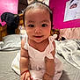 Marilu joined the competition — help win amazing prizes! baby, child, infant, white_dress, bow_headband, smiling, bed, blanket, wooden_headboard, pink_wall, portrait, indoors, bracelet, cute, face, person, small_hands, small_feet, photography, cozy_room