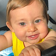 Woody joined the competition — help win amazing prizes! baby, child, smile, face, hand, yellow_shirt, indoor, closeup, curly_hair, skin, eyes, toy, bed, blanket, infant, cute, young_child, portrait, happy, person