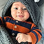 baby, blanket, child, cozy, cute, face, hand, happy, hood, indoors, infant, knitted, navy, onesie, orange, portrait, smiling, soft, striped, warm
