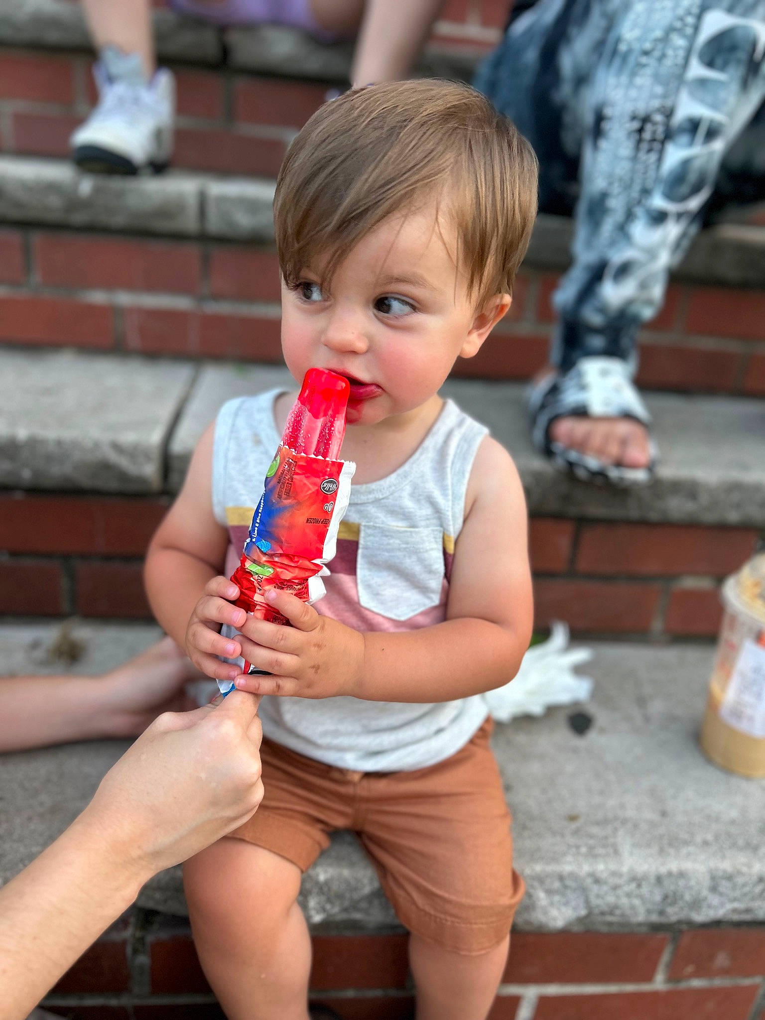 Luchiano is registered to the contest to win money with this photo: child, drink, drinking, event, finger, fun, happy, human_leg, leg, leisure, nail, person, recreation, shorts, sitting, street, summer, thigh, thumb, toddler