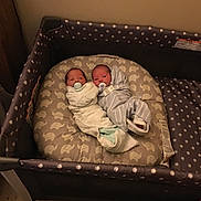 Leavon And Novael is registered to the contest to win money with this photo: newborn, baby, swaddled, blanket, playpen, cushion, elephant_pattern, pacifier, infant, indoor, sleeping, cute, twin, bedroom, floor, child, person, soft, resting, cozy