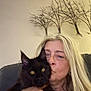 Elvis Aleksandr is registered to the contest to win money with this photo: affection, black_cat, blond_hair, blurred, cat, close_up, couch, cozy, face, feline, furniture, holding, home_decor, indoor, kiss, metal_art, pet, portrait, tree_decor, woman