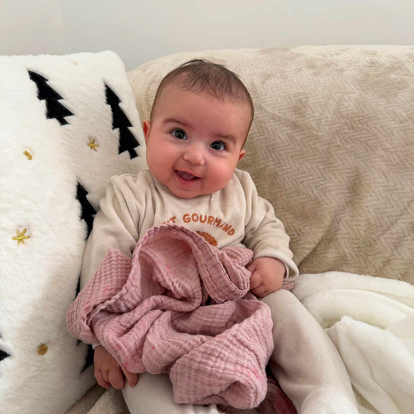 Talya participe au concours pour gagner de l'argent avec cette photo : baby, blanket, child, clothing, comfort, couch, cozy, cute, face, happy, home, indoors, infant, pillow, portrait, sitting, smile, soft_texture, warm, young