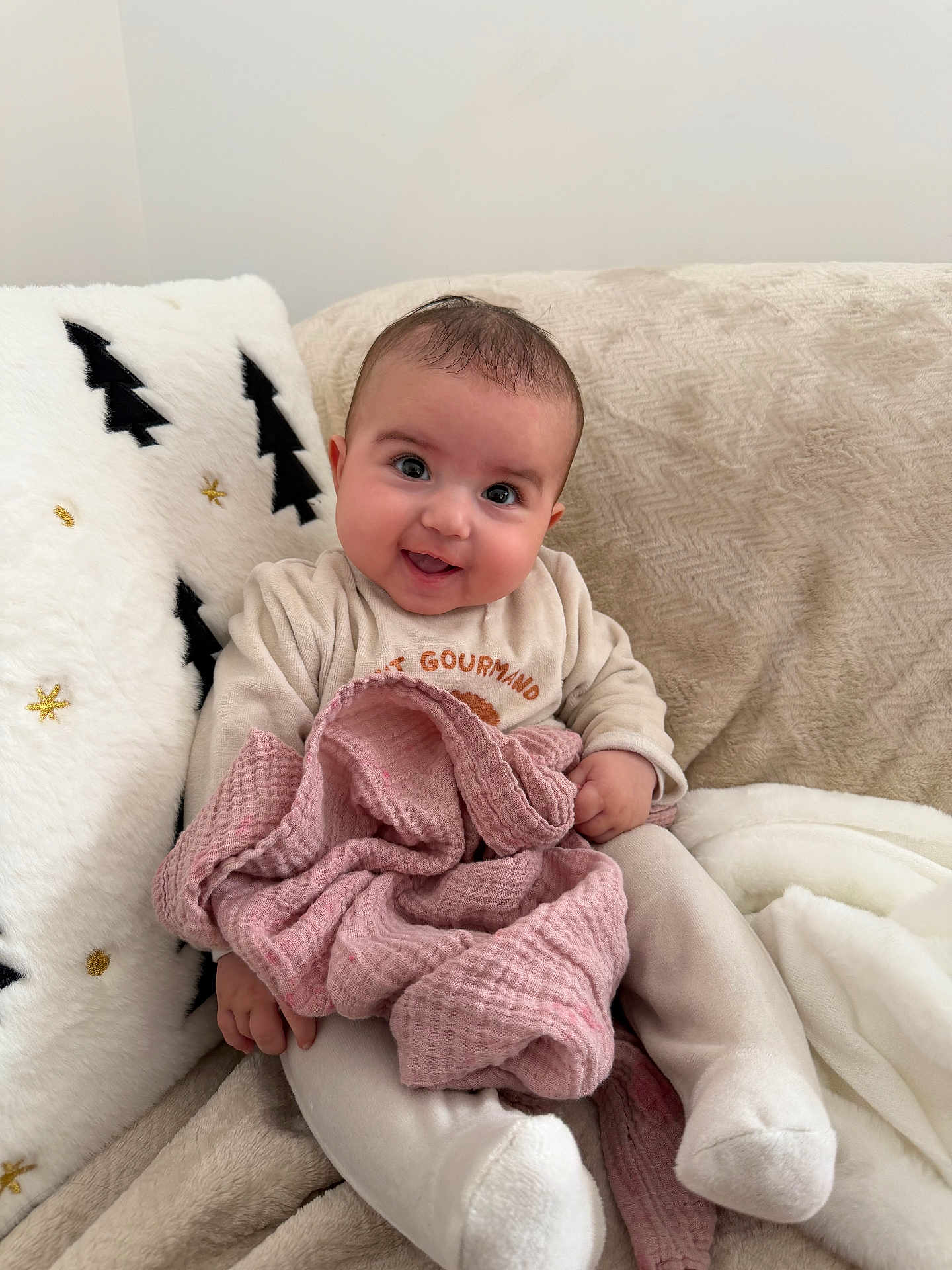 Talya participe au concours pour gagner de l'argent avec cette photo : baby, blanket, child, clothing, comfort, couch, cozy, cute, face, happy, home, indoors, infant, pillow, portrait, sitting, smile, soft_texture, warm, young