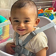 Shaam joined the competition — help win amazing prizes! toddler, child, high_chair, smiling, face, baby, seatbelt, toy, indoor, happy, person, clothing, playtime, closeup, cute, young_child, seat, infant, strap, safety