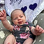 baby, infant, onesie, flower_pattern, blanket, personalized, text, hearts, cushion, seat, skin, tongue, arms, legs, cute, child, playful, outdoor, person, smiling