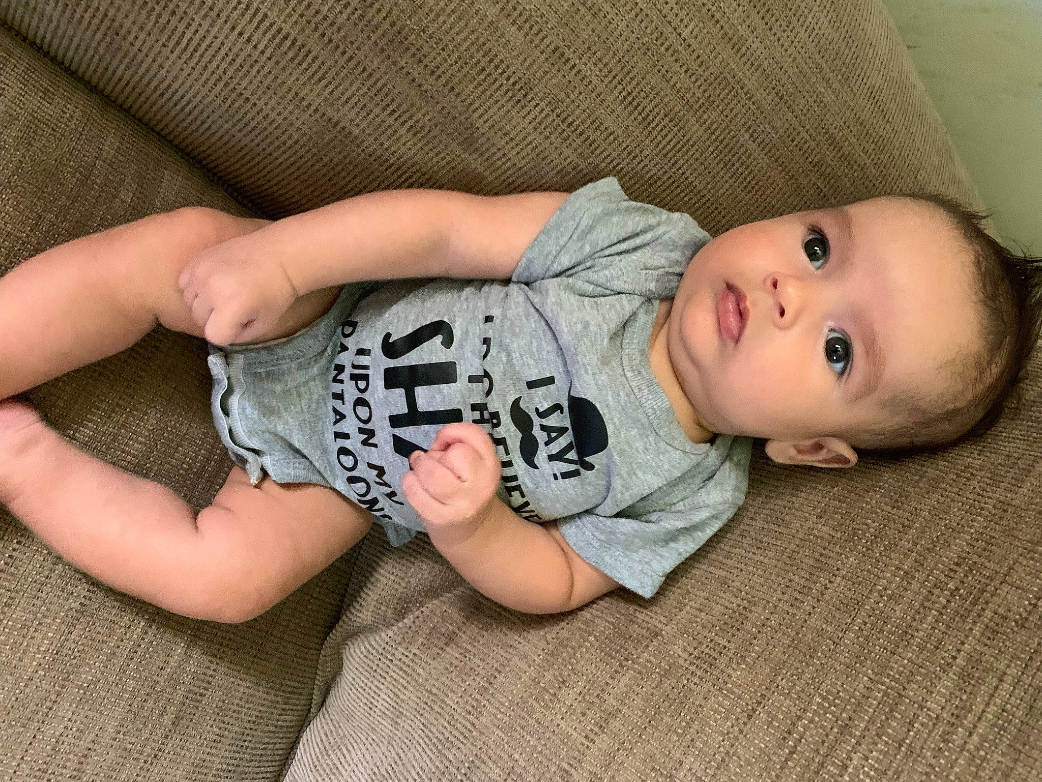 Kash is registered to the contest to win money with this photo: baby, baby_toddler_clothing, cheek, child, comfort, elbow, eye, flooring, foot, human_body, human_leg, pattern, person, sitting, skin, sleeve, t_shirt, thigh, toddler, wood