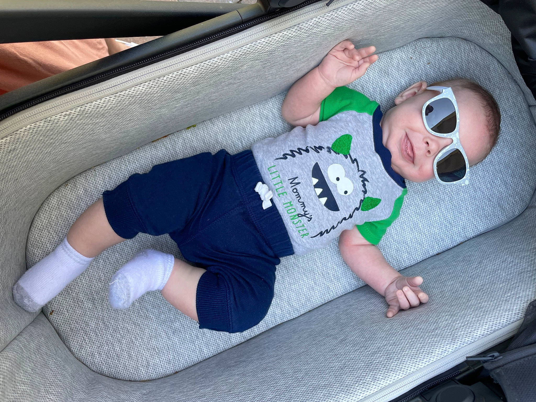 Willing is registered to the contest to win money with this photo: auto_part, automotive_design, automotive_exterior, baby, baby_toddler_clothing, bumper, car_seat, comfort, elbow, electric_blue, eyewear, finger, goggles, knee, person, sitting, sunglasses, t_shirt, thigh, toddler