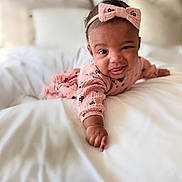 Miana joined the competition — help win amazing prizes! baby, infant, toddler, headband, bow, pink_clothing, bed, bedding, white_bed, blanket, smile, tongue_out, portrait, cute, crawling, hand, arm, face, skin, cozy
