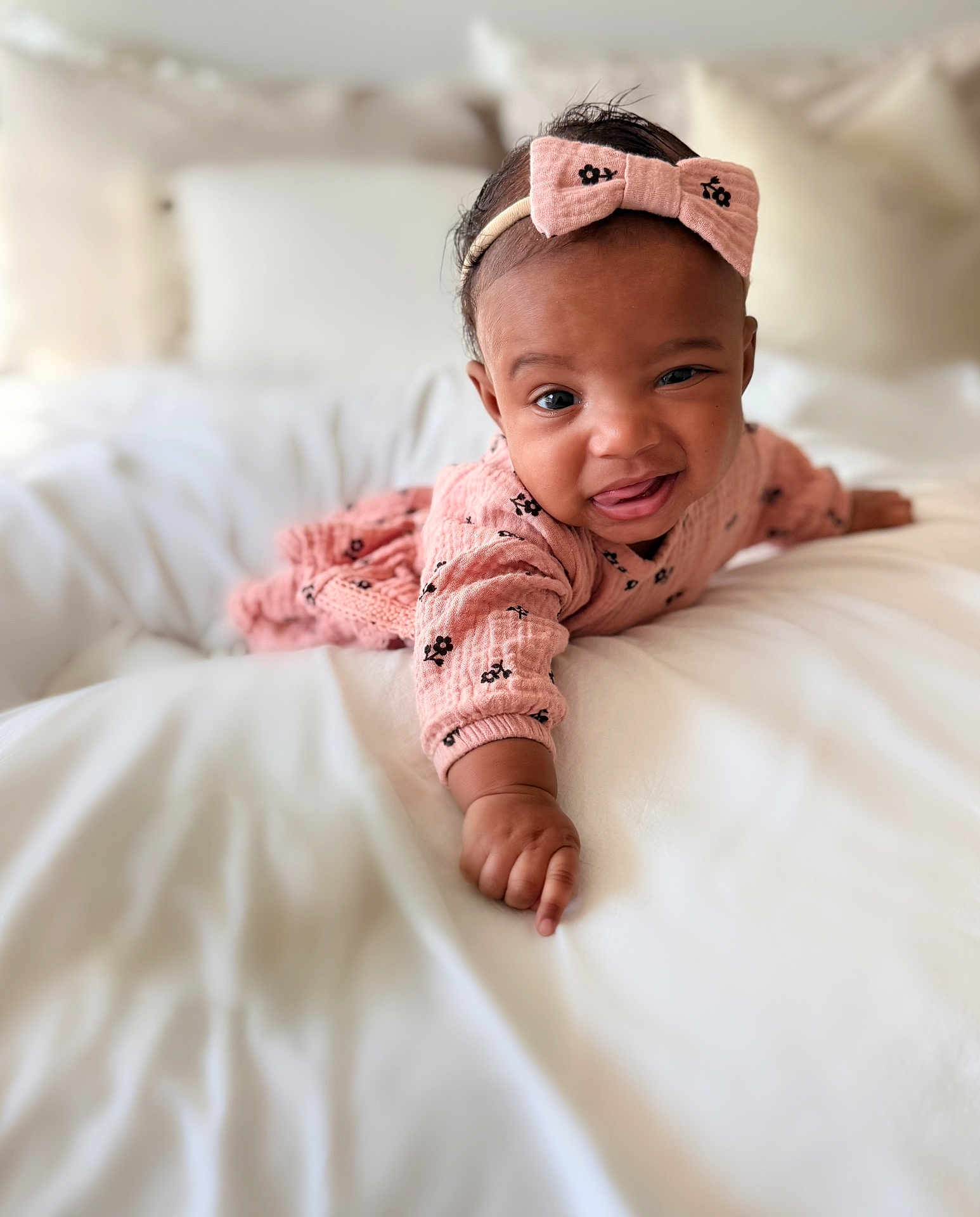 Miana joined the competition — help win amazing prizes! baby, infant, toddler, headband, bow, pink_clothing, bed, bedding, white_bed, blanket, smile, tongue_out, portrait, cute, crawling, hand, arm, face, skin, cozy