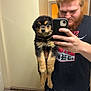 man, puppy, dog, mirror, mirror_selfie, bathroom, smartphone, beard, redhead, puppy_face, holding, pet, cute, fur, countertop, toilet_paper, t_shirt, reflection, portrait, hand
