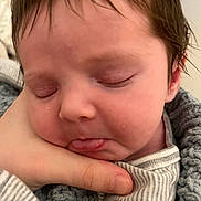 Greyson is registered to the contest to win money with this photo: baby, infant, sleeping, face, hand, tongue, blanket, striped_clothing, closeup, soft_texture, peaceful, skin, hair, newborn, person, portrait, resting, cozy, indoor, cute