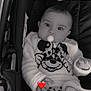 baby, pacifier, stroller, mickey_mouse, leopard_print, blanket, clothing, infant, child, cute, black_and_white, hand, face, eyes, soft_texture, warm, cozy, indoor, smiling, person