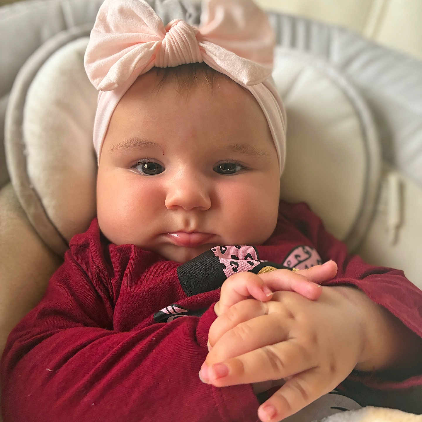 Cataleya participe au concours pour gagner de l'argent avec cette photo : baby, blanket, bow, child, closeup, clothing, cozy, cushion, cute, expression, face, hands, headband, indoors, infant, maroon, pink, portrait, seat, soft