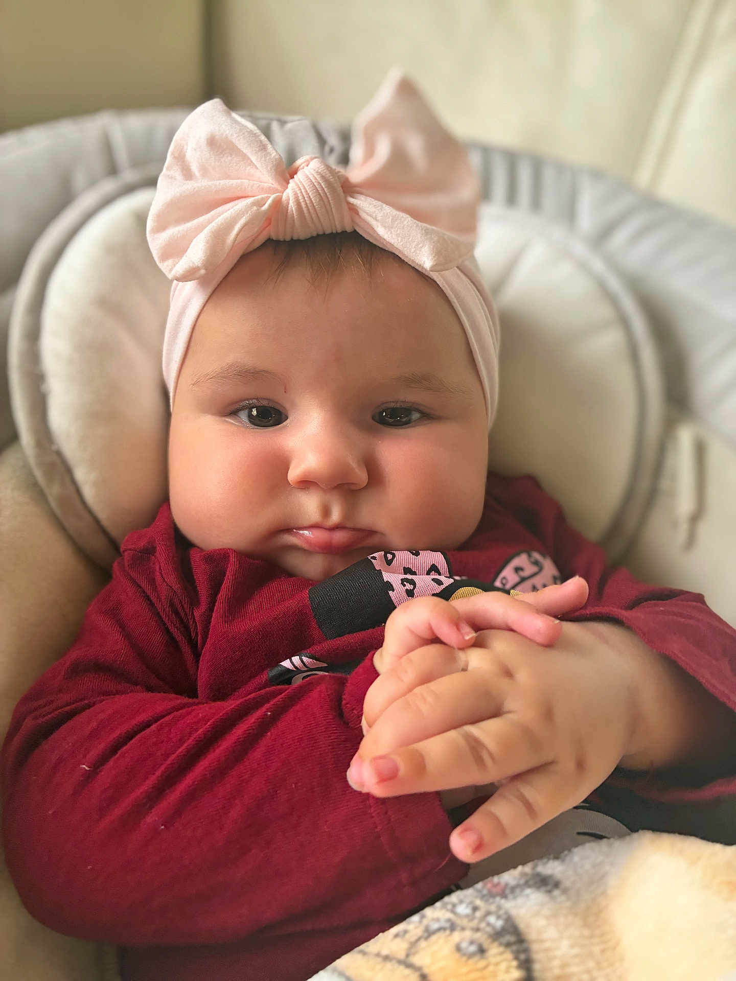 Cataleya participe au concours pour gagner de l'argent avec cette photo : baby, infant, child, headband, bow, pink, face, hands, clothing, maroon, blanket, cushion, seat, closeup, portrait, indoors, cute, expression, soft, cozy