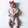 Mia a rejoint le concours — aidez-le/la à gagner de superbes lots ! baby, infant, smiling, pink_onesie, headband, bow, lying_down, shadow, white_background, cute, child, portrait, happy, soft_texture, buttoned_clothing, newborn, small_hands, tiny_feet, studio_photo, adorable