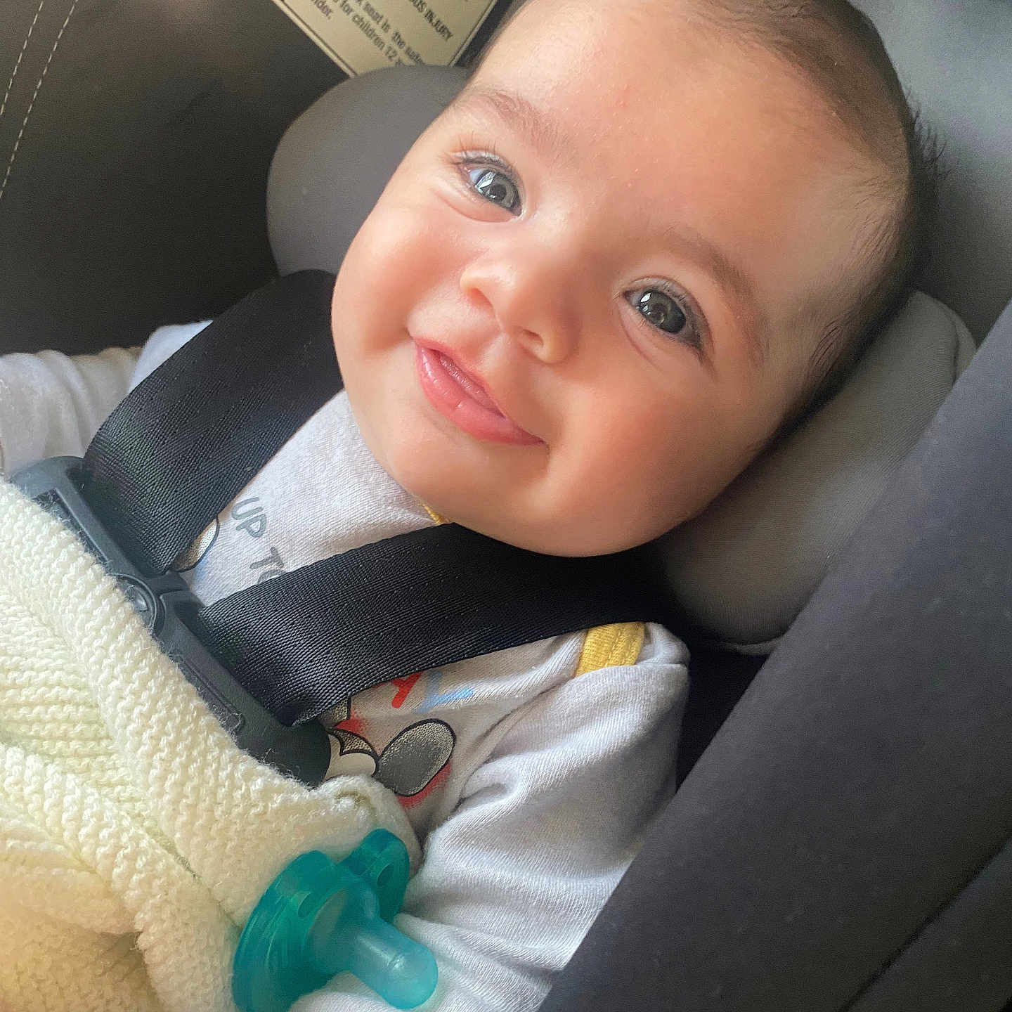 Aziz is registered to the contest to win money with this photo: baby, blanket, car_seat, child, closeup, clothing, cute, expression, happy, head_support, indoors, infant, pacifier, person, portrait, safety, seatbelt, skin, smiling, young_child