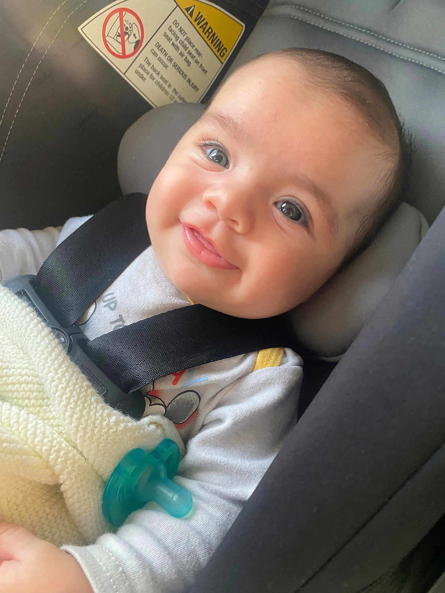 Aziz is registered to the contest to win money with this photo: baby, smiling, car_seat, blanket, pacifier, child, seatbelt, happy, closeup, infant, cute, indoors, young_child, clothing, portrait, safety, head_support, expression, skin, person