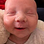 baby, smiling, face, closeup, infant, sleepy, cozy, blanket, onesie, skin, head, expression, cute, happy, child, portrait, newborn, soft, warm, peaceful