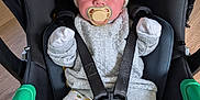 Jonyk is registered to the contest to win money with this photo: baby, sleeping, car_seat, pacifier, hat, bear_ears, clothing, socks, patterned_pants, infant, child, seatbelt, black_car_seat, wooden_floor, cute, newborn, resting, indoors, cozy, toddler