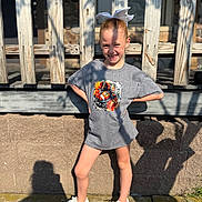 Lacie joined the competition — help win amazing prizes! child, girl, outdoor, sunlight, shadow, pose, smile, tshirt, white_bow, sneakers, fence, concrete, wall, happy, young, casual_clothing, daylight, person, standing, portrait