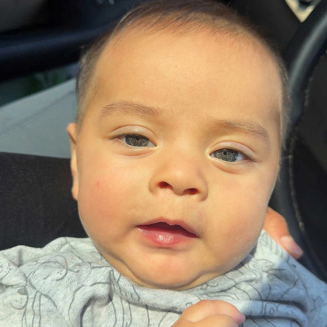 Asvel Navarrete is registered to the contest to win money with this photo: baby, car_interior, child, close_up, clothing, cute, expression, eyebrows, face, hand, head, infant, mouth, nose, onesie, person, portrait, seat, skin, sunlight