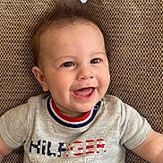 Lucus joined the competition — help win amazing prizes! baby, child, smiling, happy, couch, cushion, clothing, toddler, face, person, indoor, portrait, sitting, cute, hair, apparel, pattern, fabric, relaxing, casual