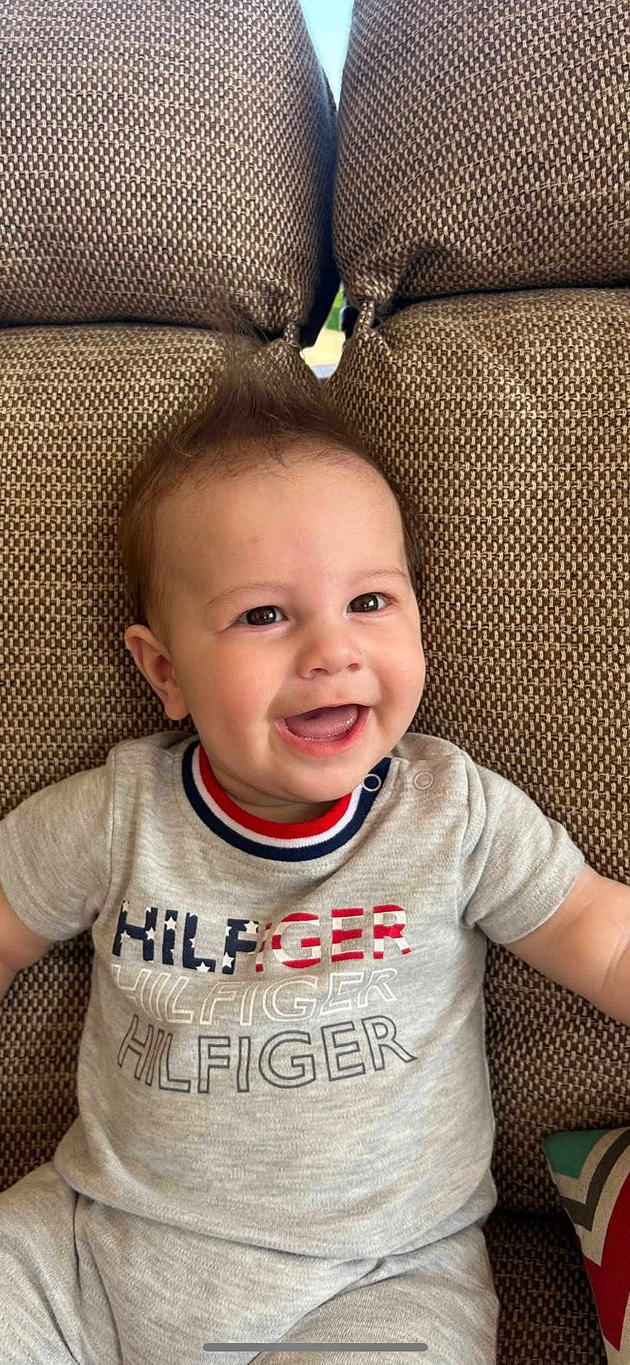 Lucus joined the competition — help win amazing prizes! baby, child, smiling, happy, couch, cushion, clothing, toddler, face, person, indoor, portrait, sitting, cute, hair, apparel, pattern, fabric, relaxing, casual