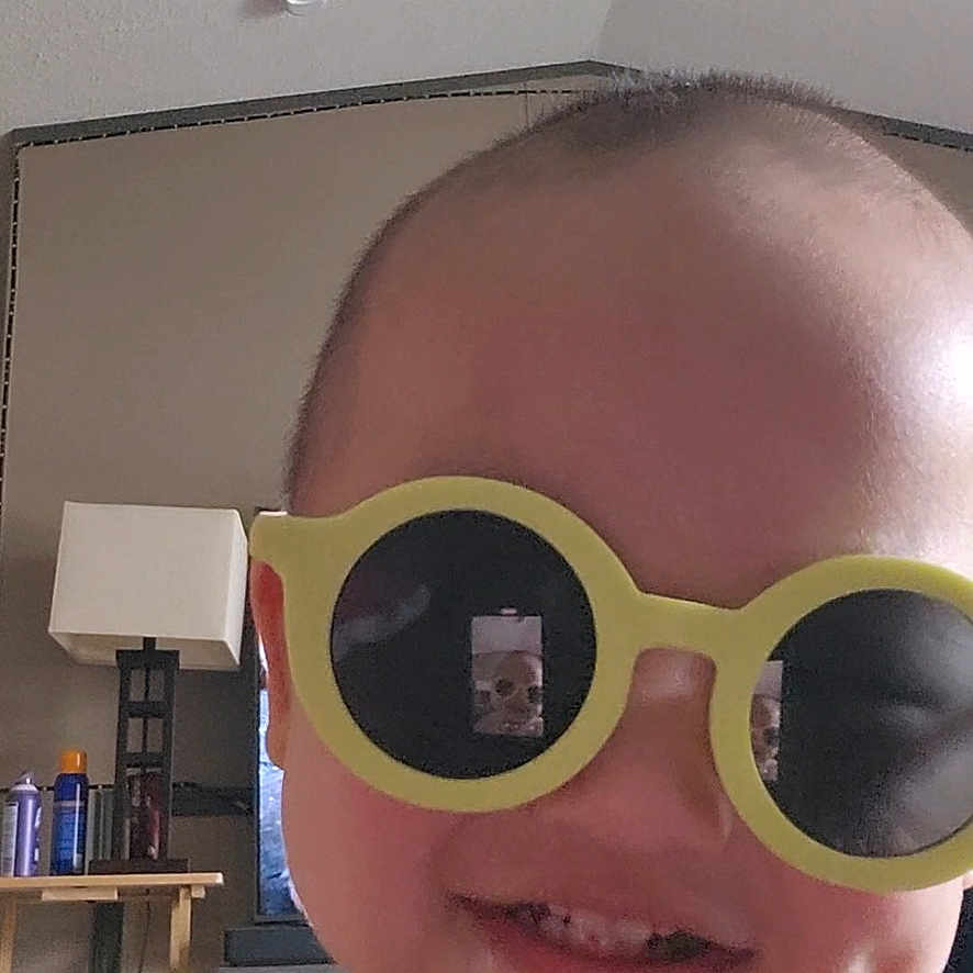 Rowan is registered to the contest to win money with this photo: accessories, architecture, baby, bodypart, clothing, face, glasses, goggles, happy, head, mouth, person, photography, portrait, selfie, smile, sunglasses, t_shirt, teeth, whiteboard