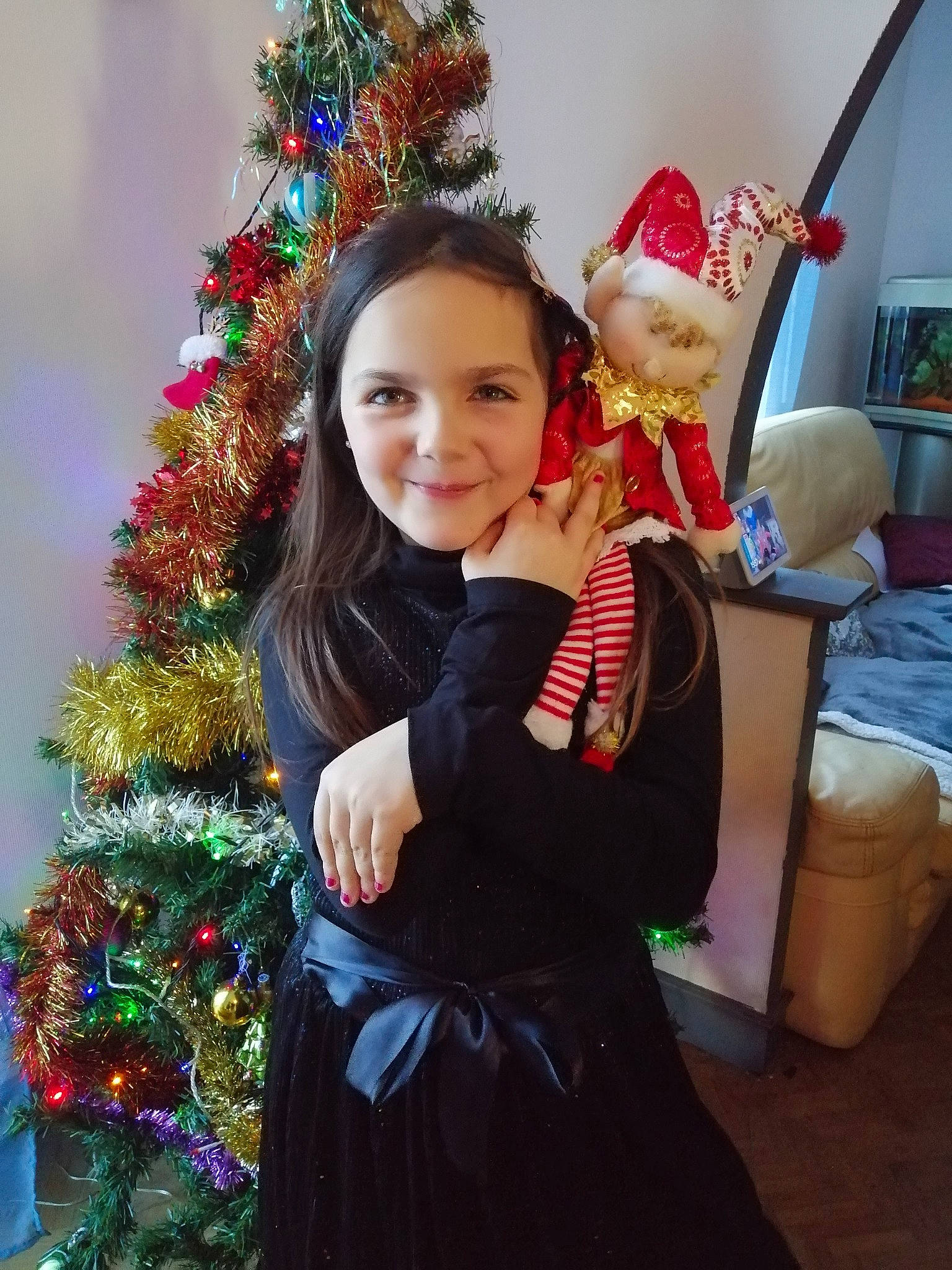 Lovely participe au concours pour gagner de l'argent avec cette photo : christmas, christmas_decoration, christmas_eve, christmas_lights, christmas_ornament, christmas_tree, costume_accessory, costume_hat, event, fictional_character, holiday, holiday_ornament, human_body, interior_design, joy, ornament, person, pine_family, shipping_box, stuffed_toy