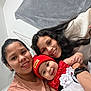 Kaori Delgado is registered to the contest to win money with this photo: baby, woman, smile, indoor, portrait, red_beanie, red_dress, white_dress, happy, family, togetherness, casual_clothing, curly_hair, long_hair, watch, selfie, face, people, candid, closeup
