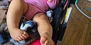 Kaori Hinata Delgado joined the competition — help win amazing prizes! baby, infant, stroller, blanket, pink_clothing, foot, hand, wooden_floor, indoor, person, happy, smile, face, cozy, plush, cushion, child, casual, relaxed, home