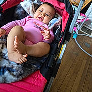 Kaori Hinata Delgado is registered to the contest to win money with this photo: baby, infant, stroller, blanket, pink_clothing, smiling, happy, indoor, wood_floor, baby_toys, baby_accessories, person, cute, child, cozy, baby_girl, baby_feet, baby_hands, casual, home