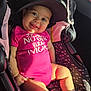 baby, child, car_seat, cap, pink_outfit, smiling, tongue_out, socks, sunlight, seatbelt, infant, cute, portrait, happy, indoor, person, seat, clothing, headwear, car_interior