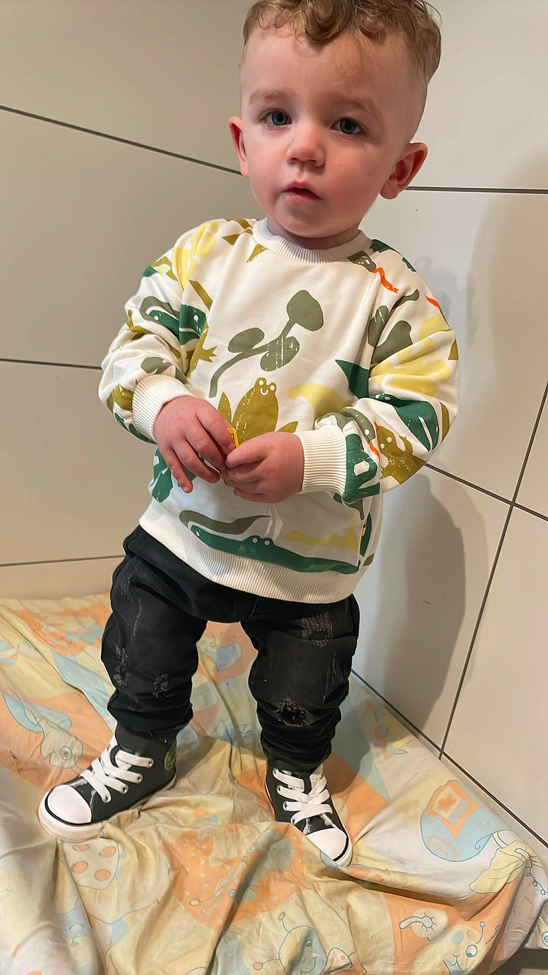 Ryan participe au concours pour gagner de l'argent avec cette photo : baby, baby_toddler_clothing, cheek, child, denim, flooring, human_leg, long_sleeved_t_shirt, nightwear, pattern, person, sitting, sleeve, t_shirt, thigh, toddler, top