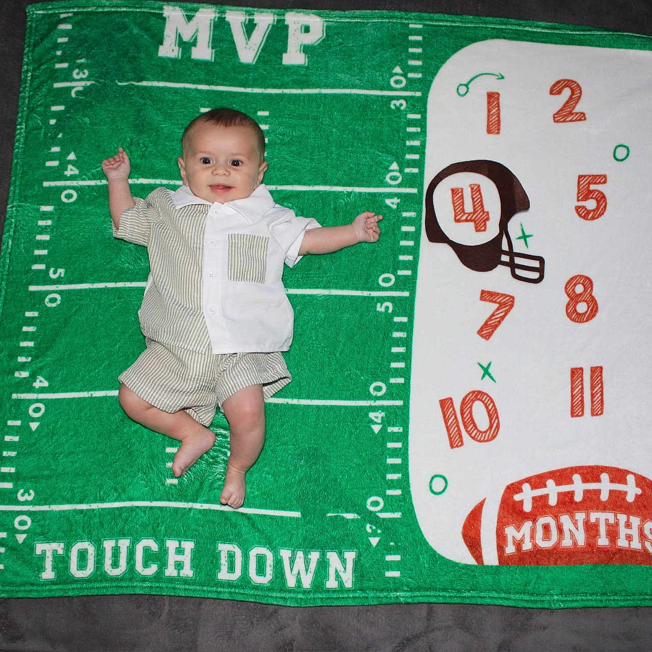 Nico joined the competition — help win amazing prizes! baby, infant, milestone_blanket, football, green, white, numbers, months, helmet, clothing, smile, happy, cute, child, blanket, laying_down, indoor, person, portrait, celebration