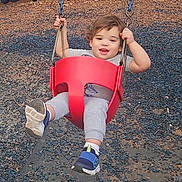 Isaac joined the competition — help win amazing prizes! toddler, child, swing, playground, red_swing, smiling, happy, outdoor, casual_clothing, gray_pants, blue_shoes, short_hair, child_playing, fun, daylight, recreation, park, holding_on, joyful, young_child