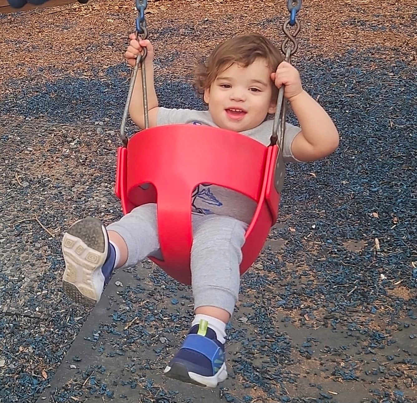 Isaac joined the competition — help win amazing prizes! toddler, child, swing, playground, red_swing, smiling, happy, outdoor, casual_clothing, gray_pants, blue_shoes, short_hair, child_playing, fun, daylight, recreation, park, holding_on, joyful, young_child