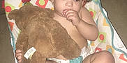 Isaac joined the competition — help win amazing prizes! baby_chair, child, colorful_pattern, cozy, curly_hair, cute, diaper, floor, footwear_off, home, indoor, person, plush_toy, relaxed, seated, soft_toy, stuffed_animal, thumb_sucking, toddler, young_child