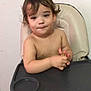 toddler, child, high_chair, indoor, person, skin, hair, face, hands, tray, seat, expression, brown_hair, young_child, furniture, bare_chest, curly_hair, looking_down, contemplative, sitting