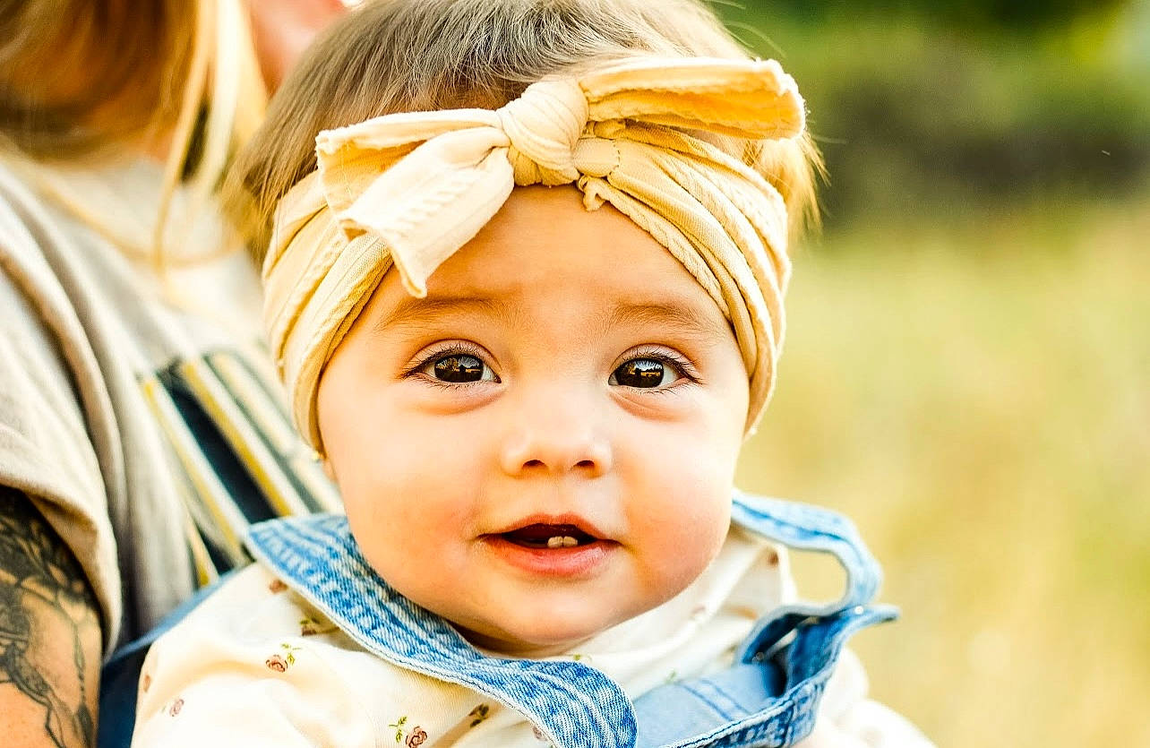 Brylee is registered to the contest to win money with this photo: baby, baby_toddler_clothing, blond, cheek, child, ear, eye, eyebrow, eyelash, fashion_accessory, fun, grass, happy, headband, headwear, iris, laugh, nose, person, skin