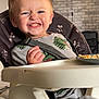 Diego Pieddefer a rejoint le concours — aidez-le/la à gagner de superbes lots ! toddler, child, high_chair, food, smile, mischievous, face, indoor, messy, clothing, seatbelt, plate, table, hair, expression, person, cute, funny, skin, blue_eyes