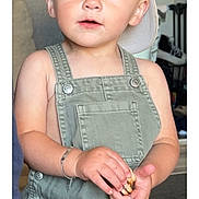 Diego Pieddefer participe au concours pour gagner de l'argent avec cette photo : blonde_hair, blue_eyes, bracelet, cap, casual_clothing, child, closeup, curious, cute, face, hands, indoor, light_skin, overalls, person, portrait, sitting, snack, toddler, young_child
